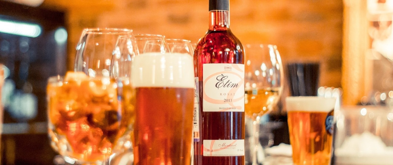 genstande-oel-og-vin Glas med øl og en flaske vin på en bardisk