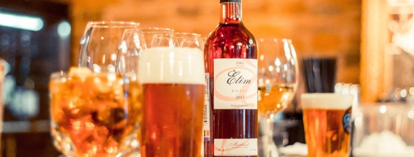 Glas med øl og en flaske vin på en bardisk